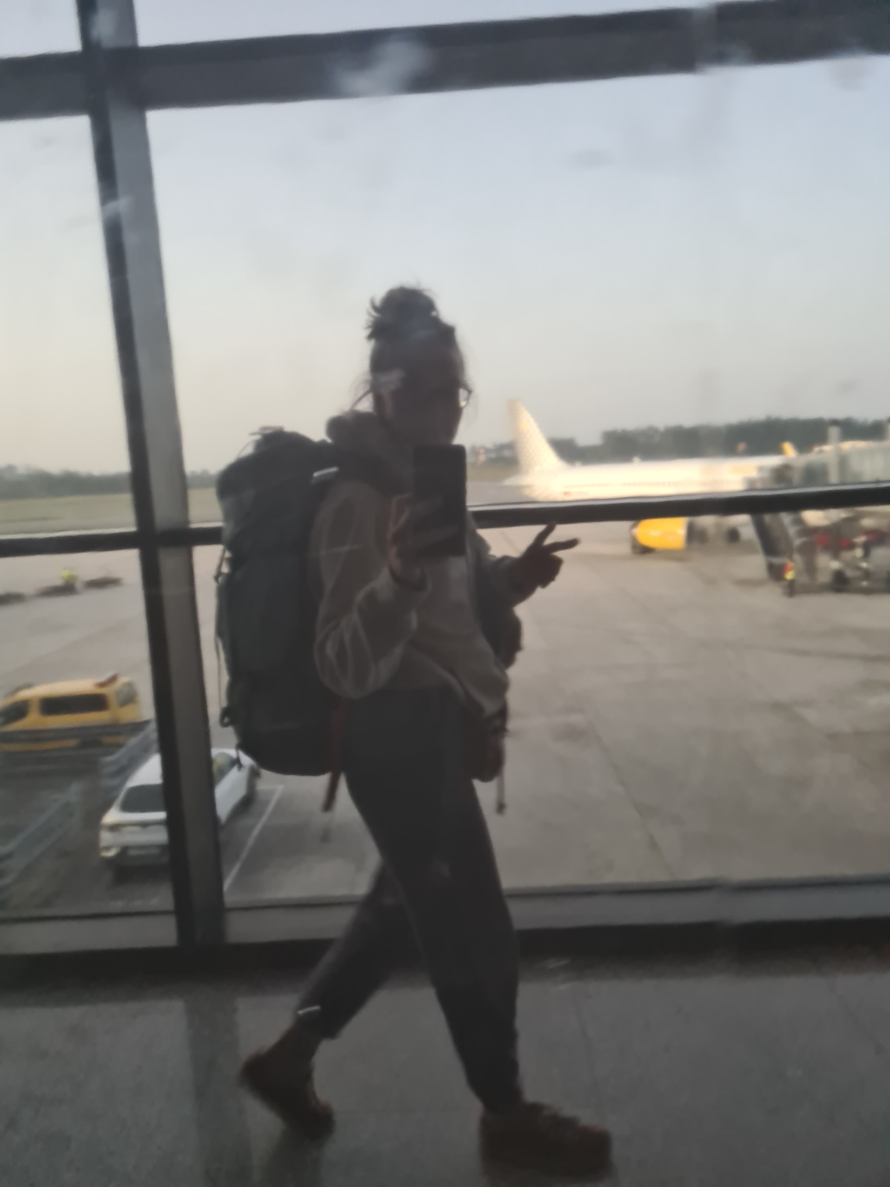 Reflejo en espejo de aeropuerto con mochila